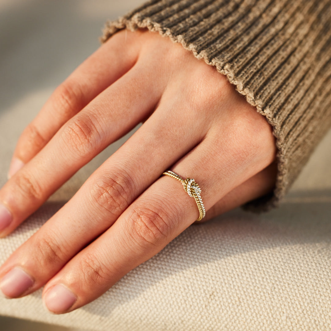 A handcrafted two-strand knot ring symbolizing the unbreakable bond between mothers and daughters.