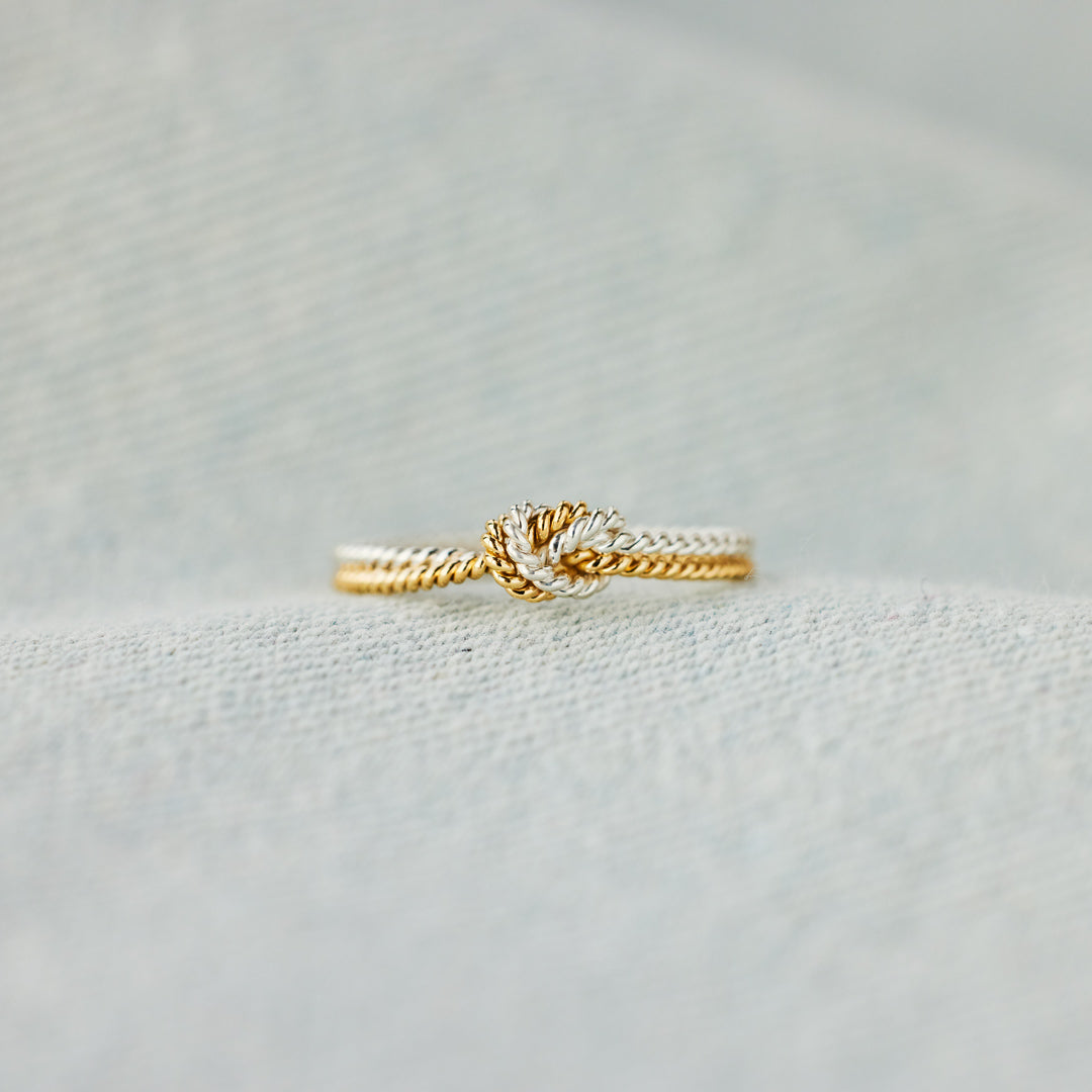 A handcrafted two-strand knot ring symbolizing the unbreakable bond between mothers and daughters.