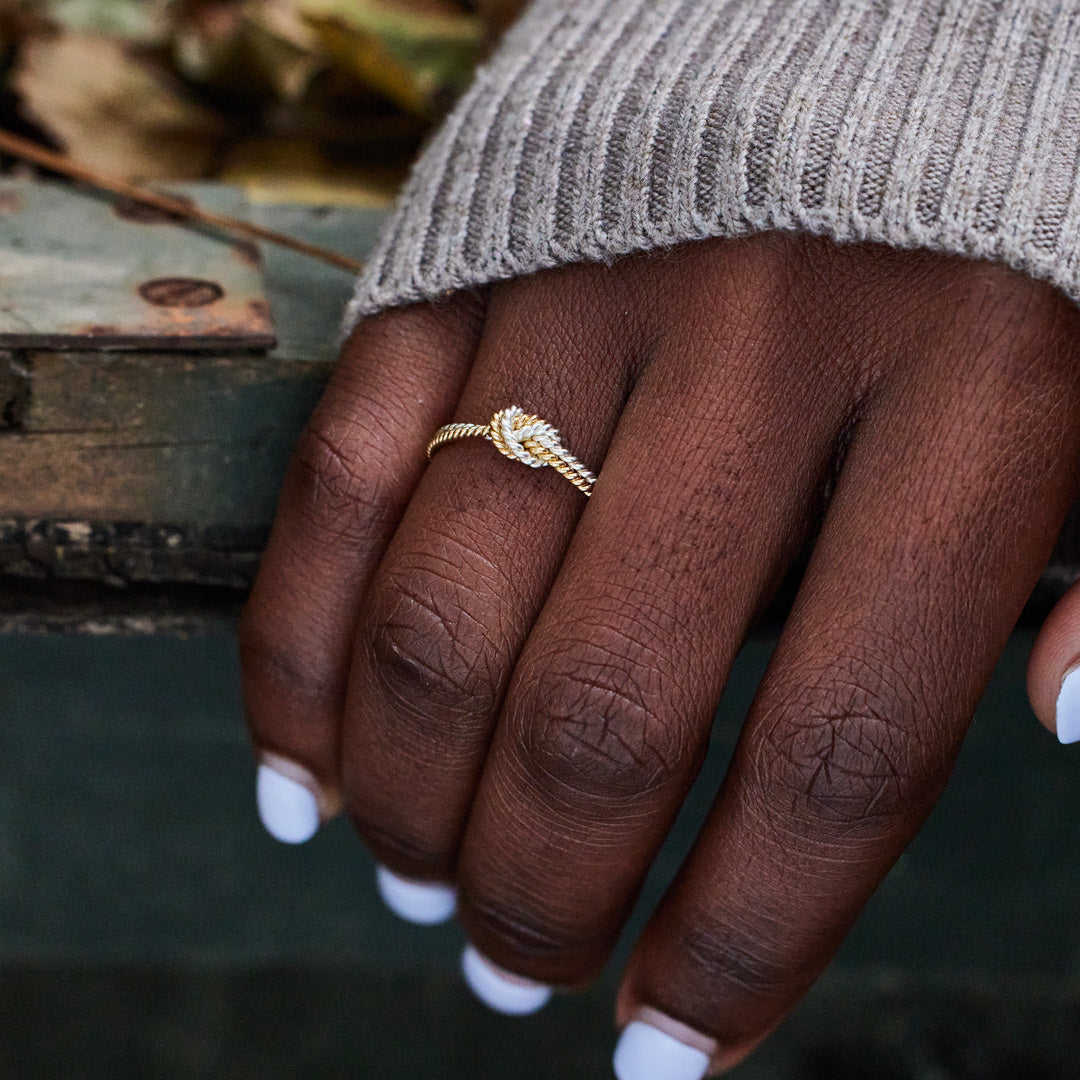 A handcrafted two-strand knot ring symbolizing the unbreakable bond between mothers and daughters.